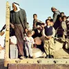 Gruppo di persone, molte famiglie e bambini, su un camion in un contesto di crisi.