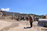 Illica, frazione del comune di Accumoli in provincia di Rieti, Italia centrale: un'anziana signora guarda i resti della sua casa distrutta dal terremoto del 2016. 