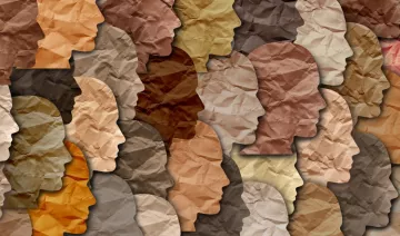 La imagen presenta una composición de siluetas de rostros en diferentes tonos de color. Las siluetas están organizadas de manera que se superponen y se integran entre sí, creando un efecto visual interesante. Los colores varían desde tonos claros hasta oscuros, y la textura del papel arrugado añade profundidad a la imagen. Esta representación puede simbolizar la diversidad y la variedad de identidades.