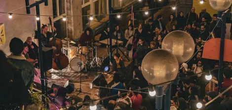 Concert animé dans un lieu chaleureux, éclairé par des guirlandes lumineuses.